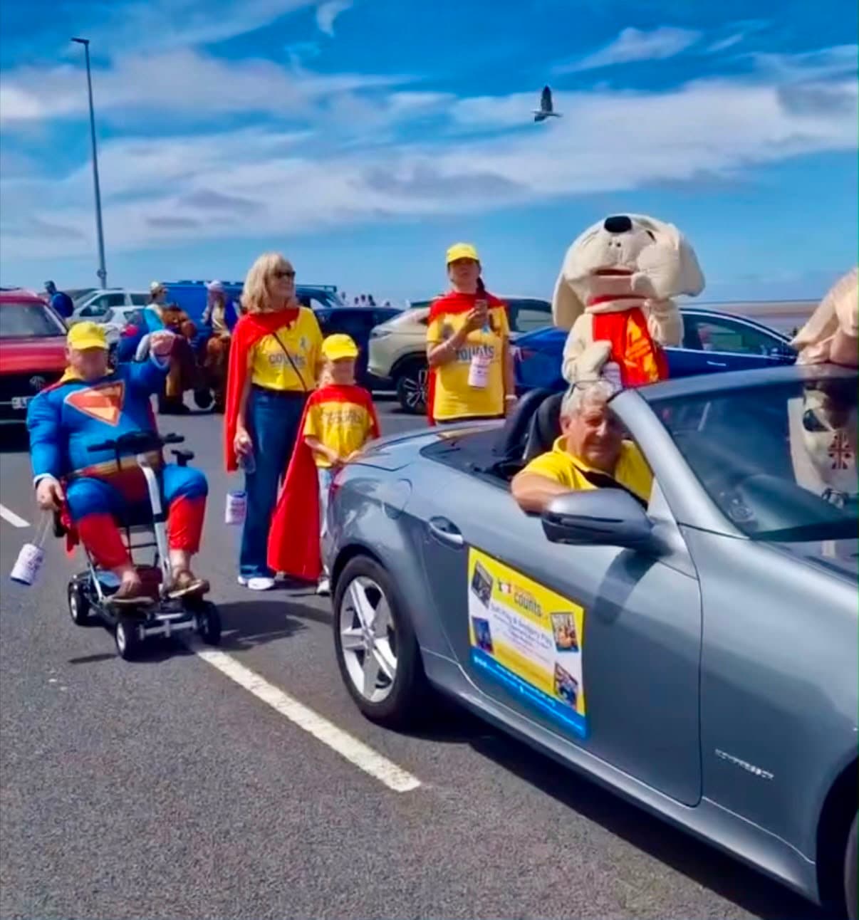 The Kindness Counts UK team in yellow shirts and red capes at Fleetwood Carnival.