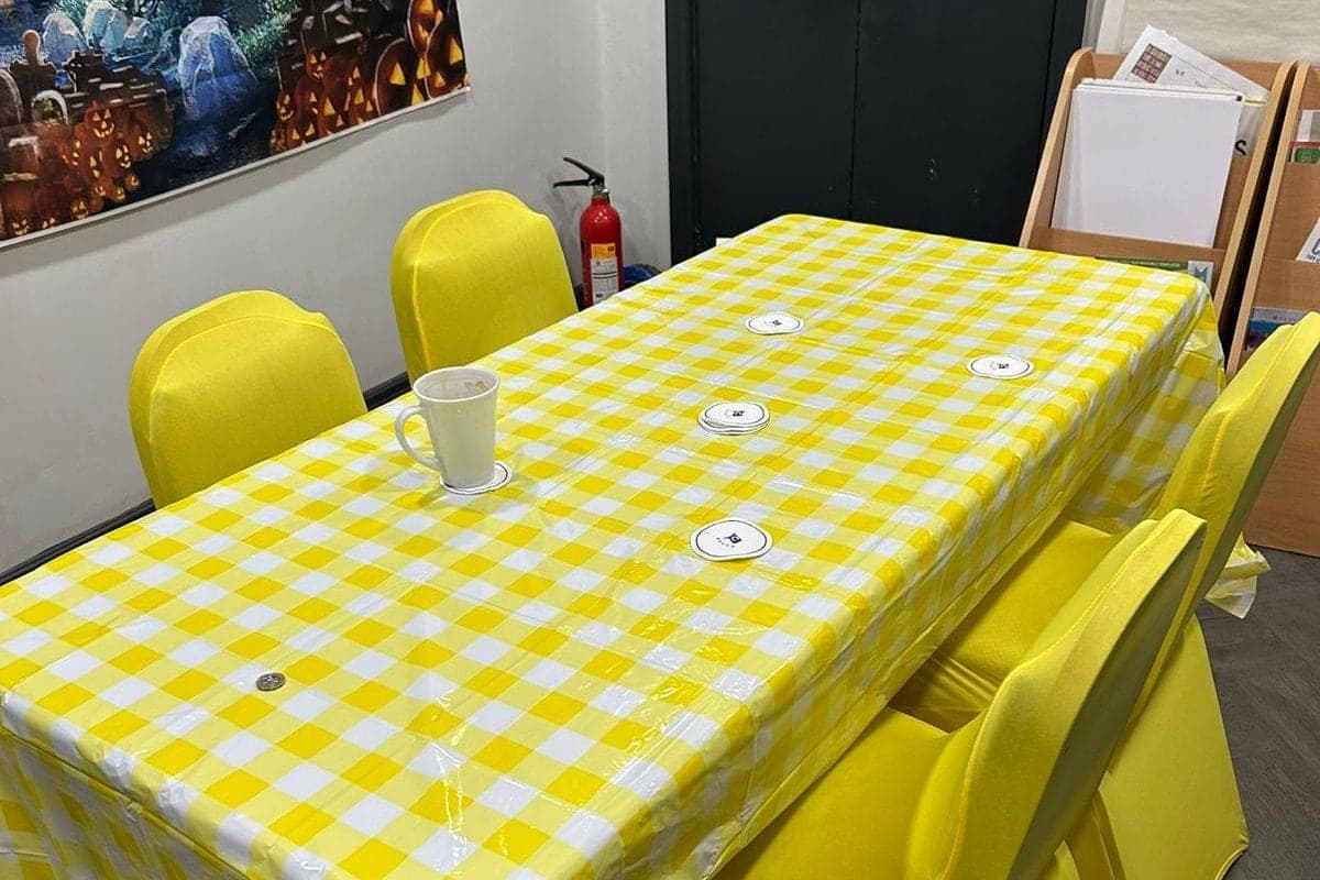 The meeting room at the hub, laid out with a yellow gingham cloth and yellow chair covers, ready for a session.