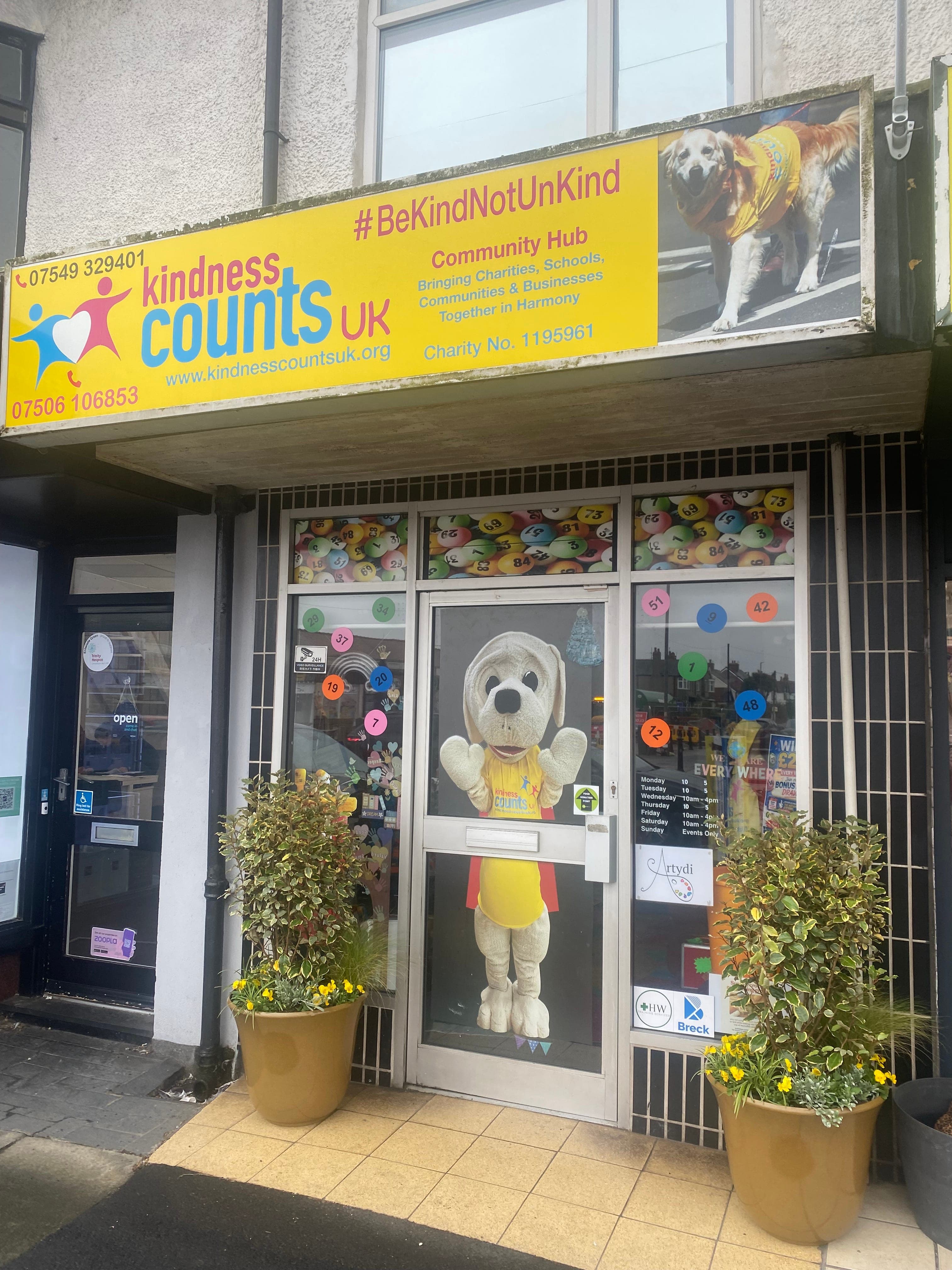 The Hub 1 shopfront on Victoria Road West, the Nic mascot costume in the doorway between two planters.