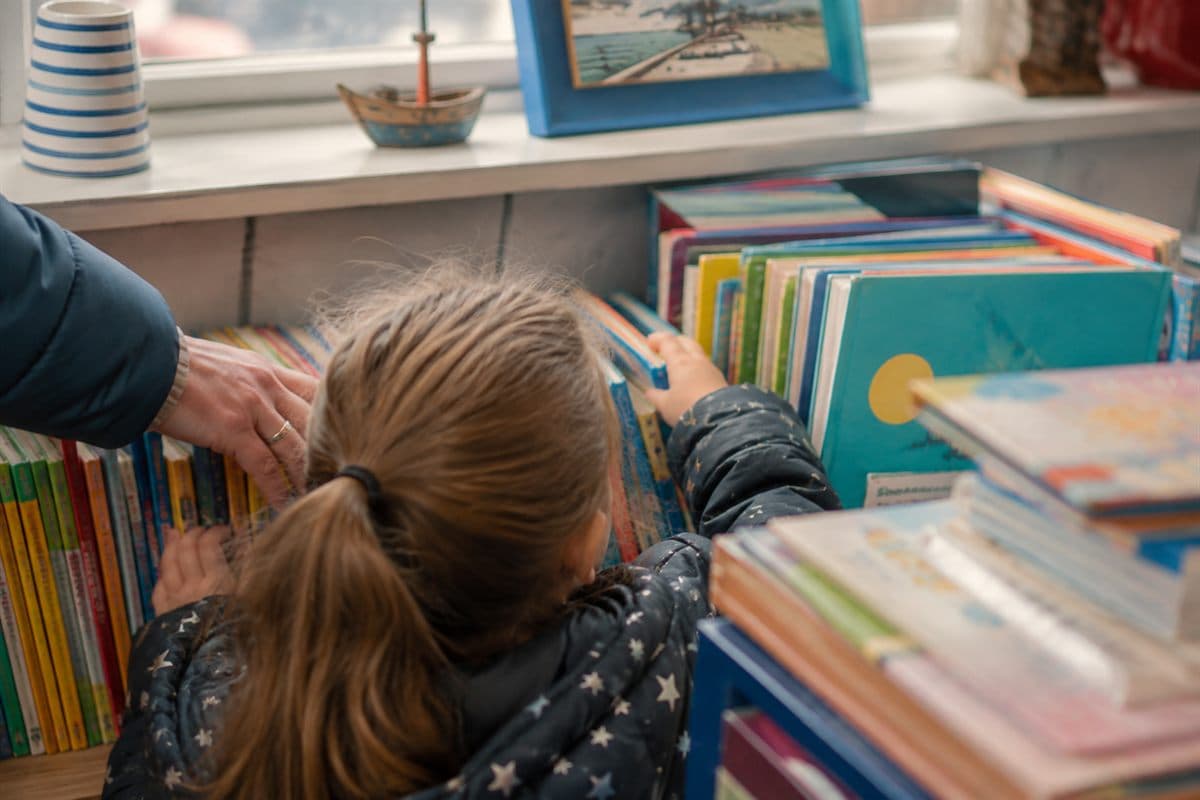 A stack of well-read children's picture books on a table.